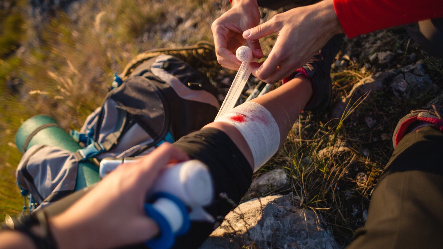 Woman getting first aid treatment after a hiking injury