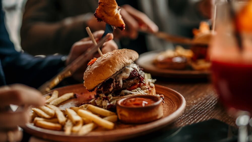 Burger and french fries served on a table in the restaurant