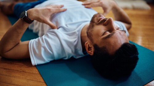 Exhausted sportsman resting on the floor during home workout.