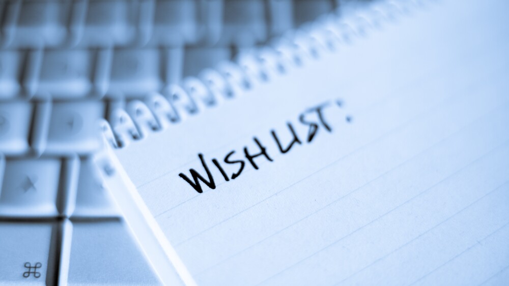 Spiral notebook on Laptop with blank Wishlist