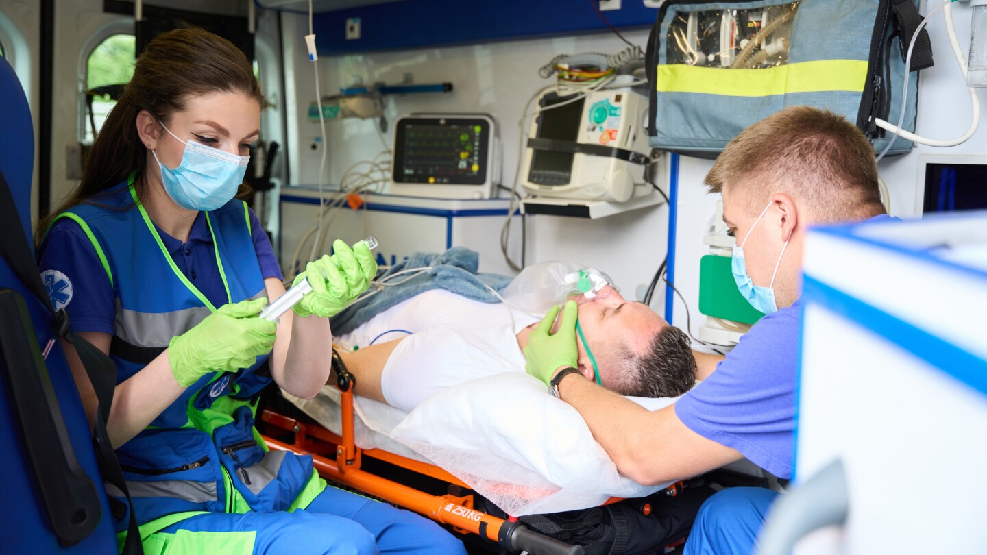 Woman doctor in an ambulance prepares a syringe with medicine