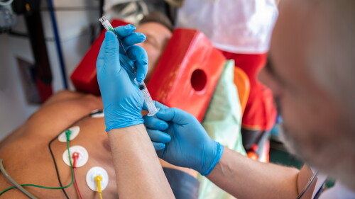 Ambulance doctor preparing to administer an injection to a patient