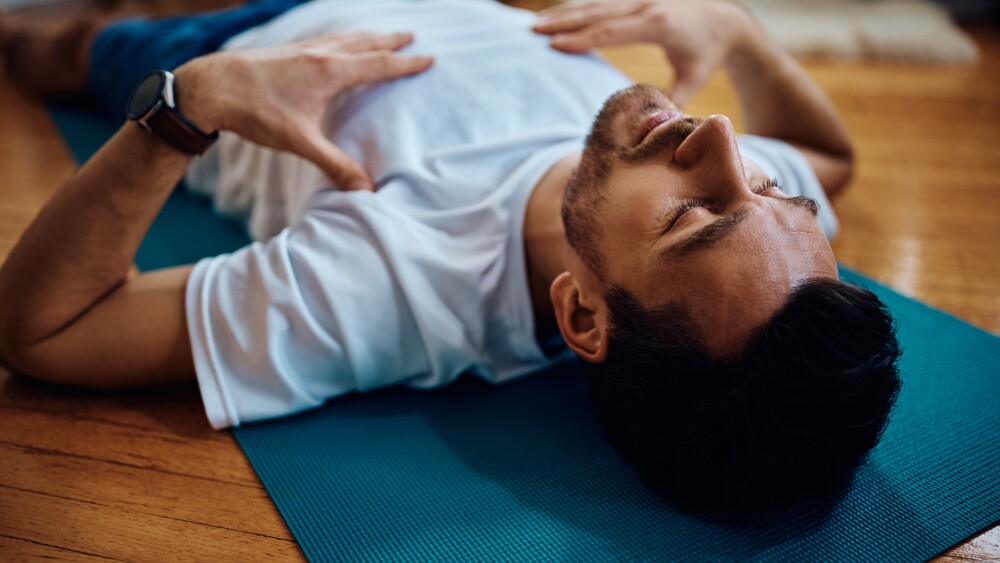 Exhausted sportsman resting on the floor during home workout.