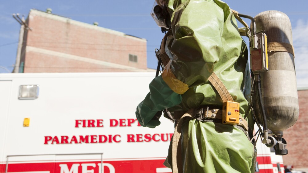 HazMat firefighter with air tank and fire truck