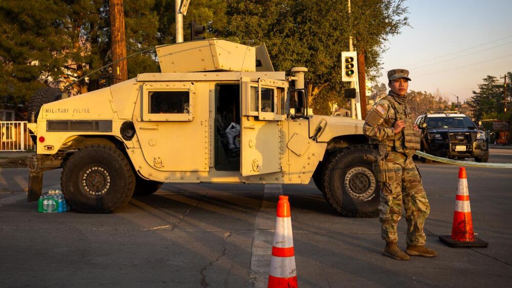 A California National Guard Military Police stands guard at a closed intersection due to the Eaton fire in Altadena